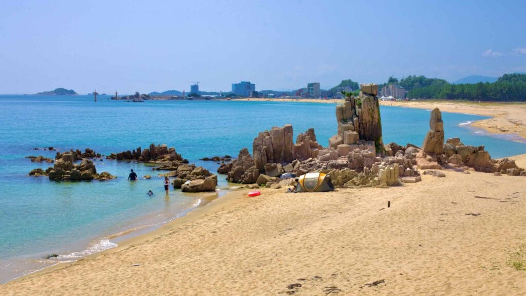 A striking rock formation stands off Gonghyeonjin Beach, surrounded by sandy shores.
