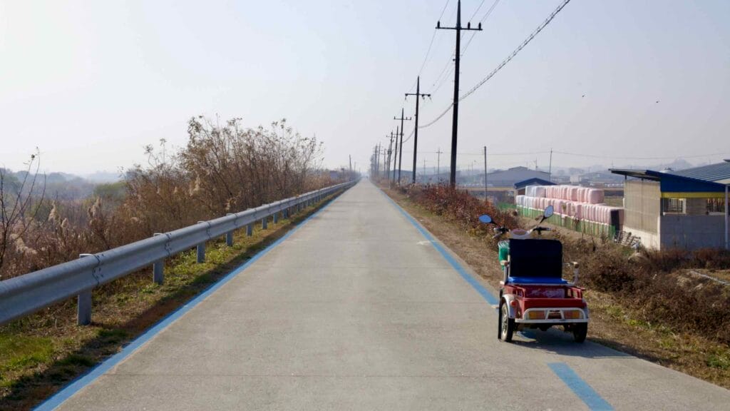 A long, empty section of the Ocheon Bicycle Path stretches into the distance.