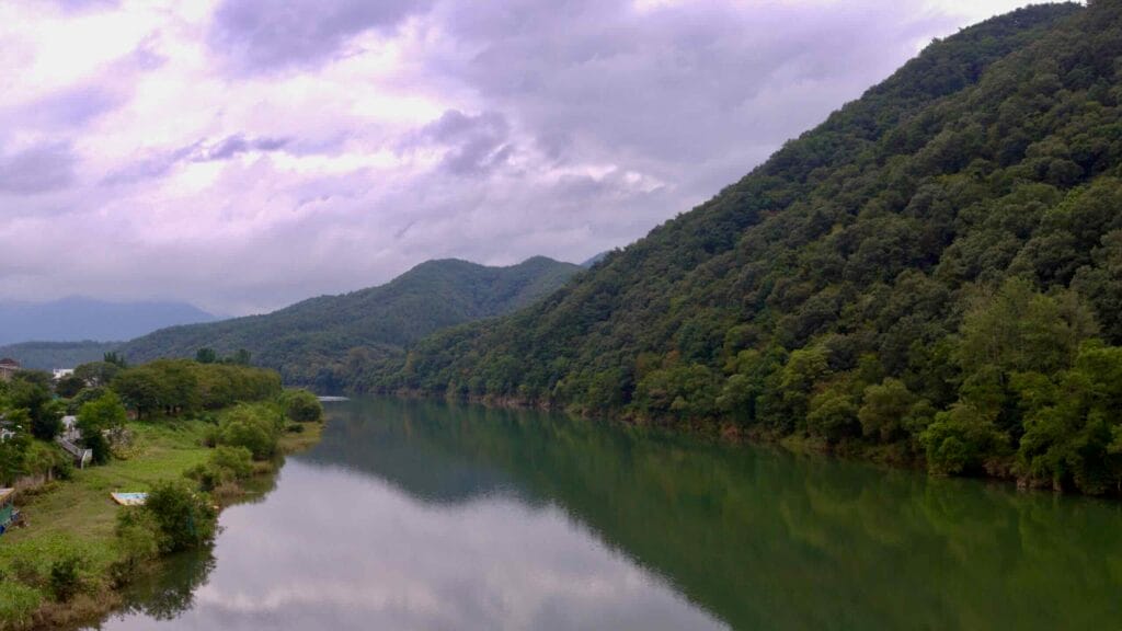 A view of Dal Stream from Goegang Bridge, with hills reflecting on the calm waters along the Ocheon Bike Path.