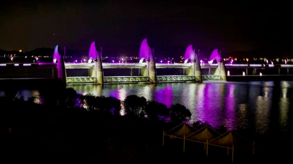 The Seungchon Weir on the Yeongsan River glows with vibrant purple illumination.