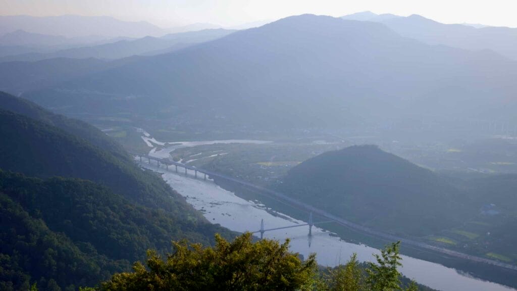 A panoramic view of the Seomjin River winding through the valley from Saseongam Hermitage.