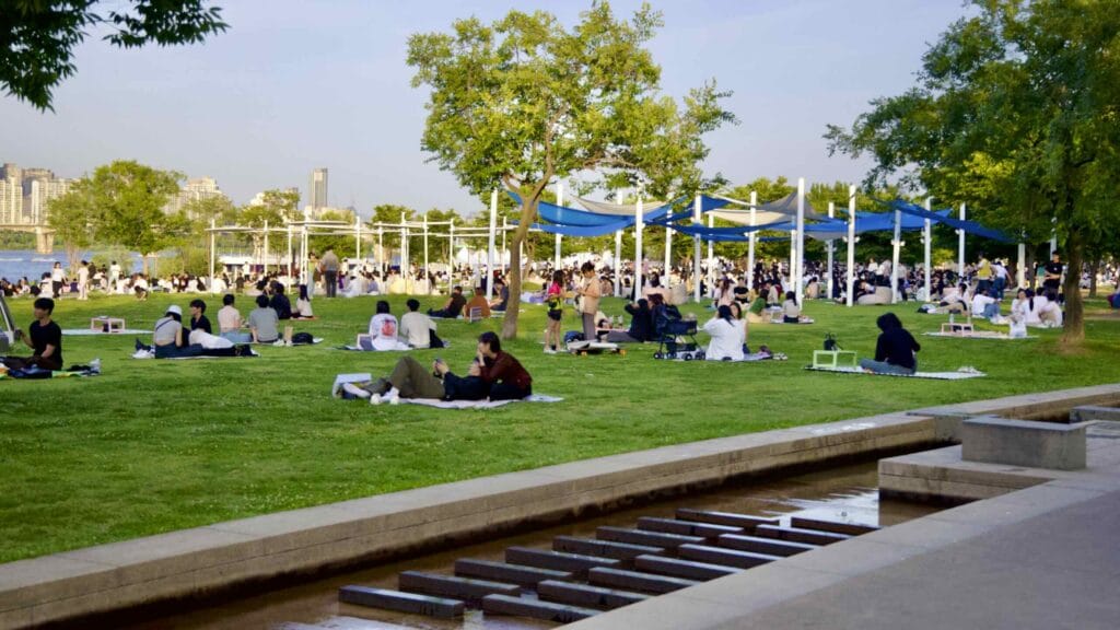 An artificial stream flows by picnic fields, under Mapo Bridge, and into Waterlight Square Fountain in Yeouido.