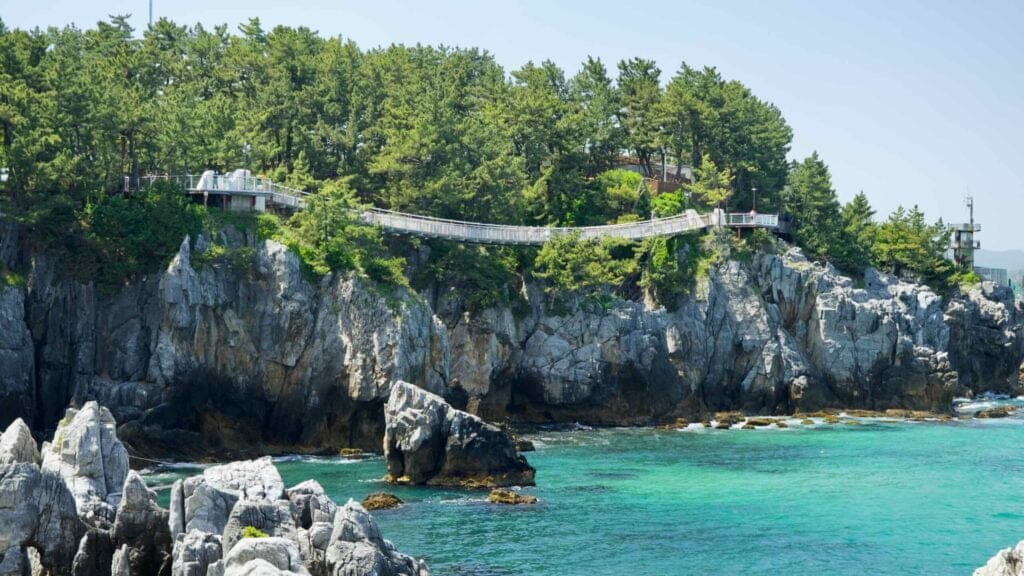 The Chuam Suspension Bridge spans the lush coastal cliffs, offering stunning views of the East Sea.