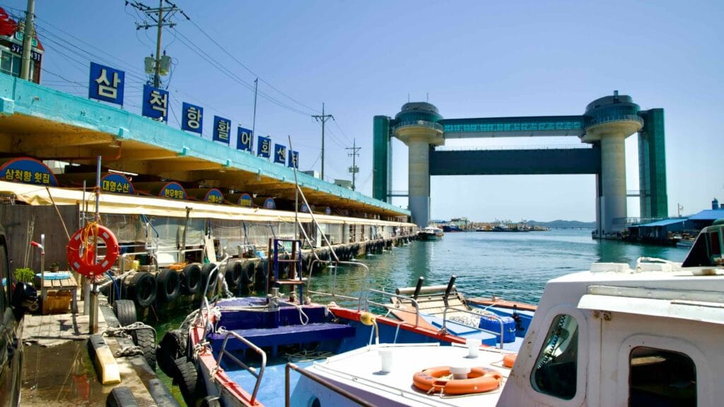 The Samcheok Port Raw Fish Center with boats docked nearby and the Tsunami Safety Tower in the background.