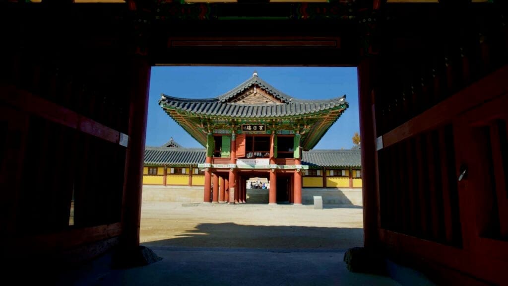 A framed view of Binilru Pavilion at Naksansa Temple, as seen through the ornate Four Heavenly Kings Gate, highlighting traditional Korean architecture.