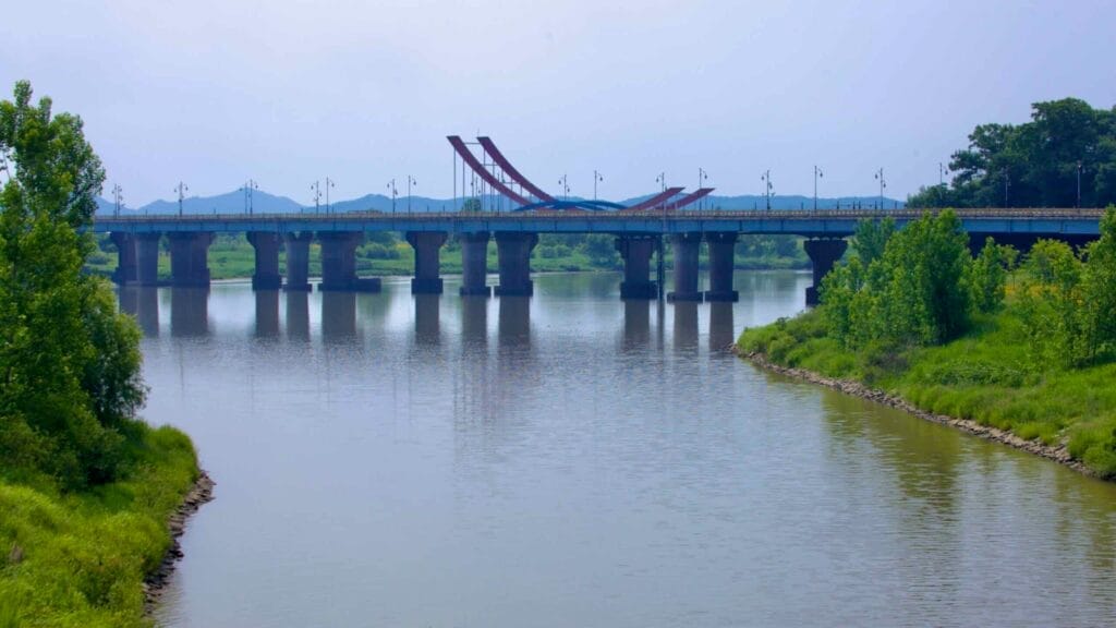 Baekje Bridge, with its distinctive red and blue sculpture-like structure, stretches across the Geum River.