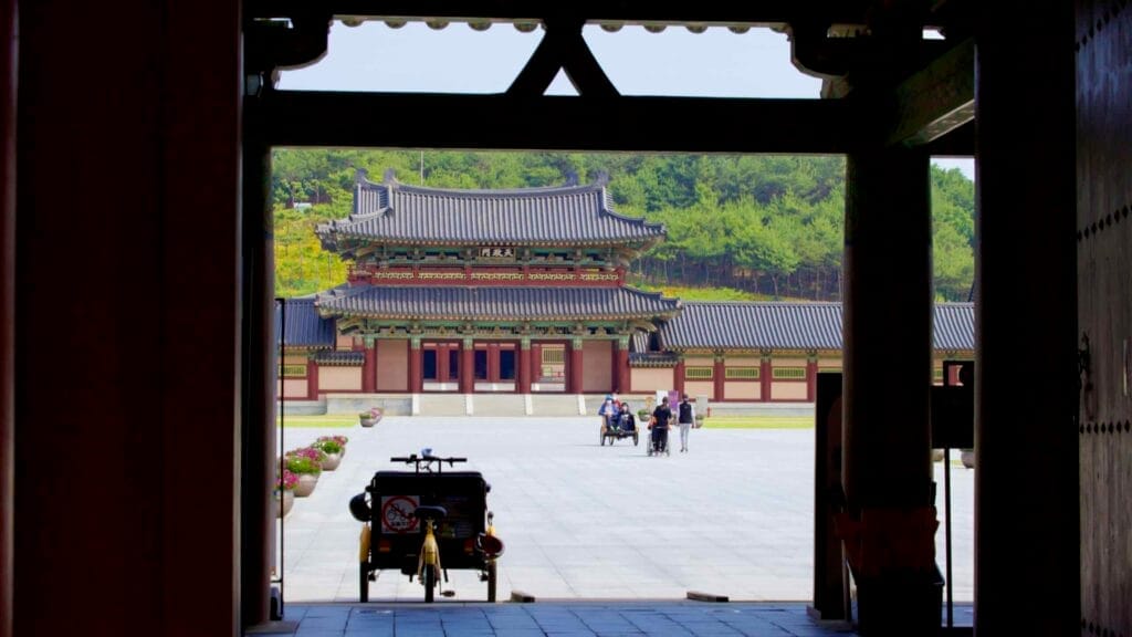 A view through the entrance gate of Baekje Cultural Land reveals the grand Sabigung Palace.
