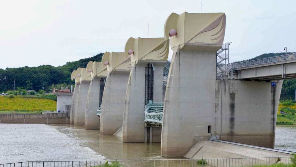 A view of Gongju Weir, highlighting its towering concrete pillars and sculpted gate structures.