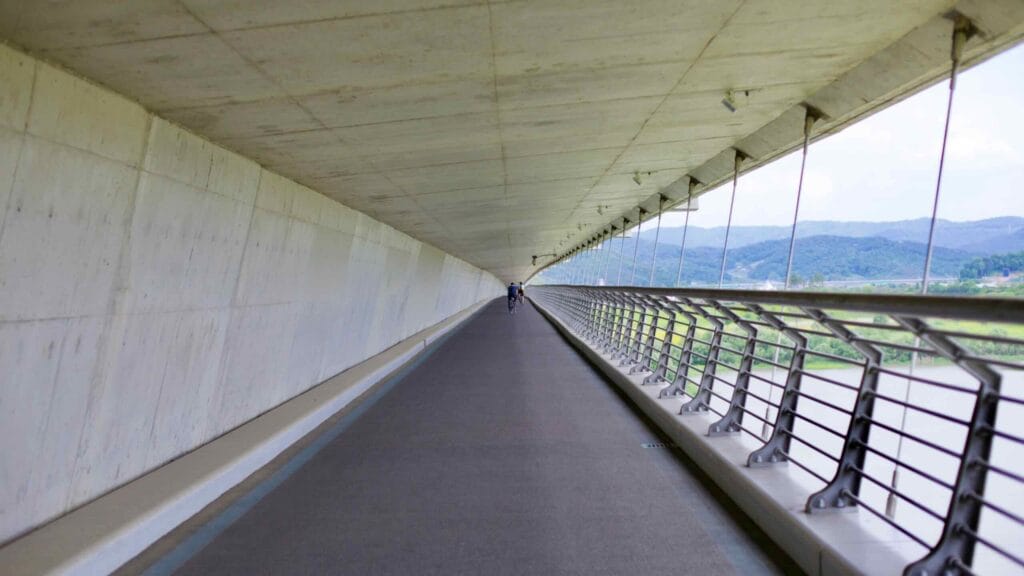 A cyclist rides along the enclosed bike and pedestrian path under Haknara Bridge.