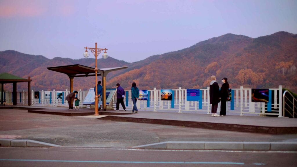 Visitors explore the scenic courtyard at Daecheong Dam, overlooking Daecheong Lake.