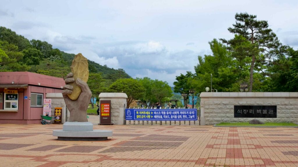 The entrance to Seokjangni Museum, featuring a striking sculpture of a hand holding a stone tool.