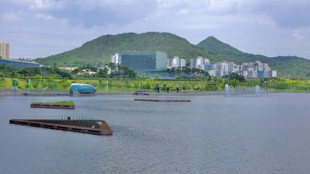 Wetlands and fountains in Sejong Lake Park’s artificial lake, with the Sejong National Library in the background.