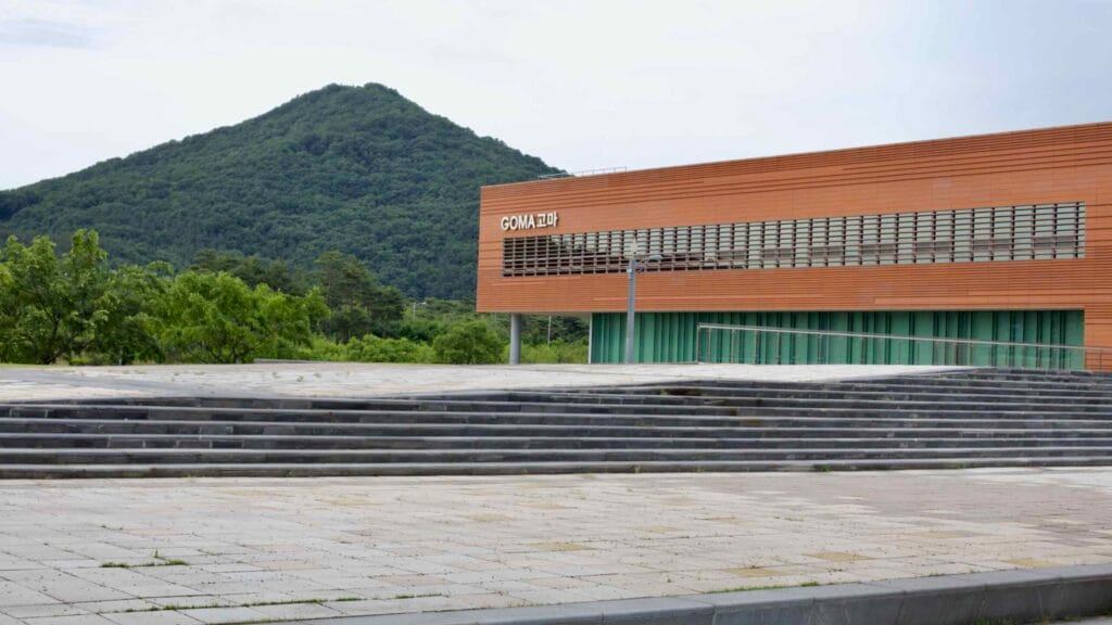 The GOMA Museum stands against the backdrop of lush green mountains.