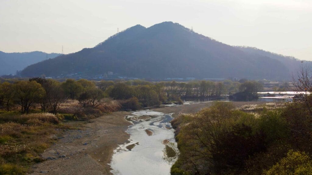 The Geum River meanders through a tranquil valley, with sandbanks and lush vegetation.