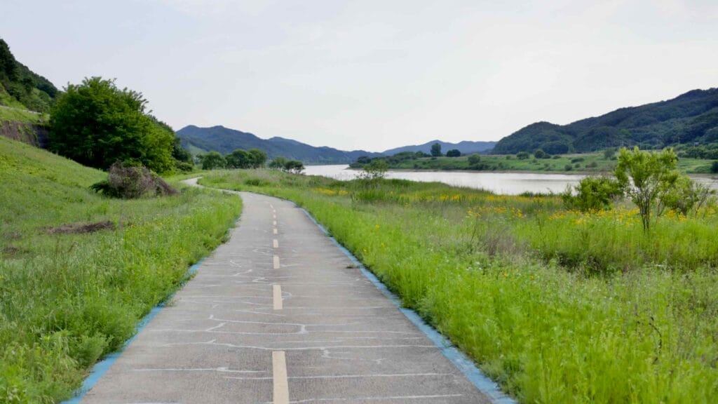 A winding cycling path follows the Geum River's edge.