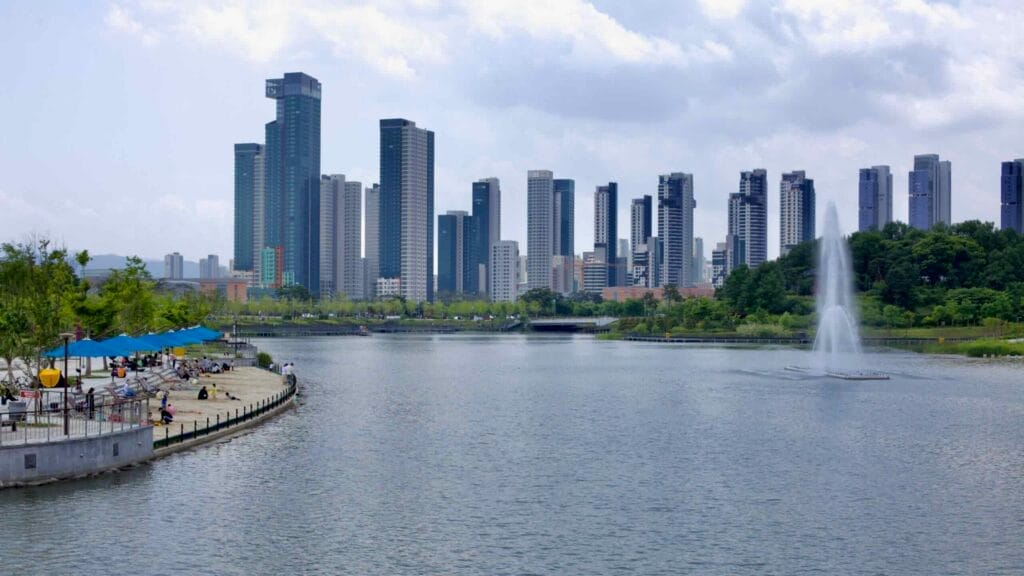 Visitors relax along the waterfront promenade at Sejong Lake Park, with a fountain display in the artificial lake.