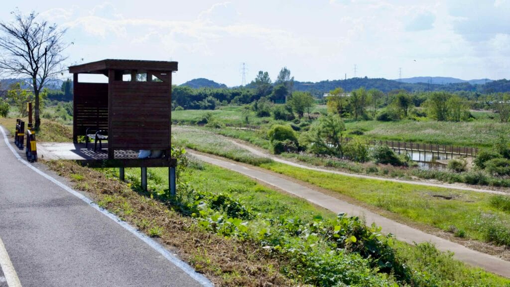 Wooden rest shelter overlooks a scenic riverside trail along the Yeongsangang Bike Path.