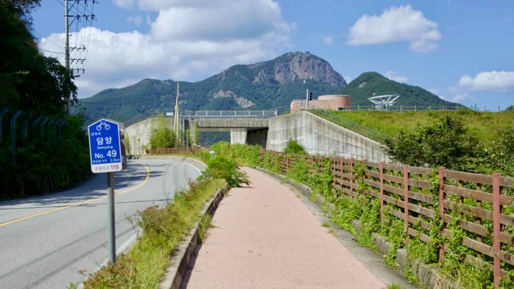 Yeongsangang Bike Path leads to Damyang Lake, with Jeonggak Mountain visible.