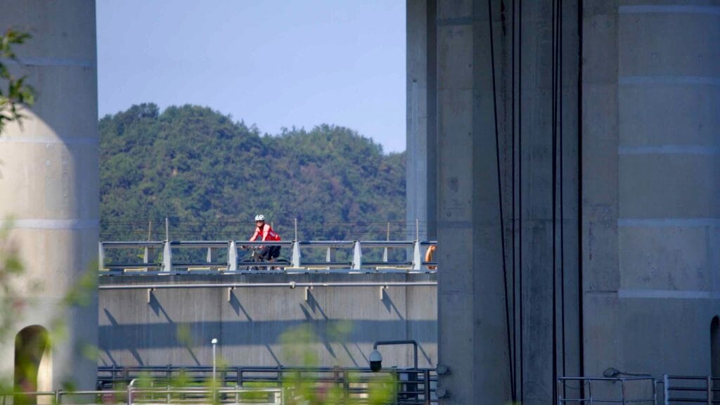 A cyclist wearing a red jacket crosses Juksan Weir on the Yeongsangang Bike Path.