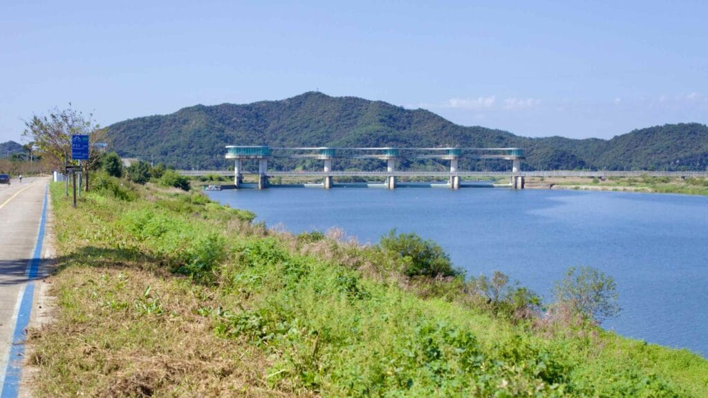 Juksan Weir spans the Yeongsan River, a hydrological structure and cycling destination.