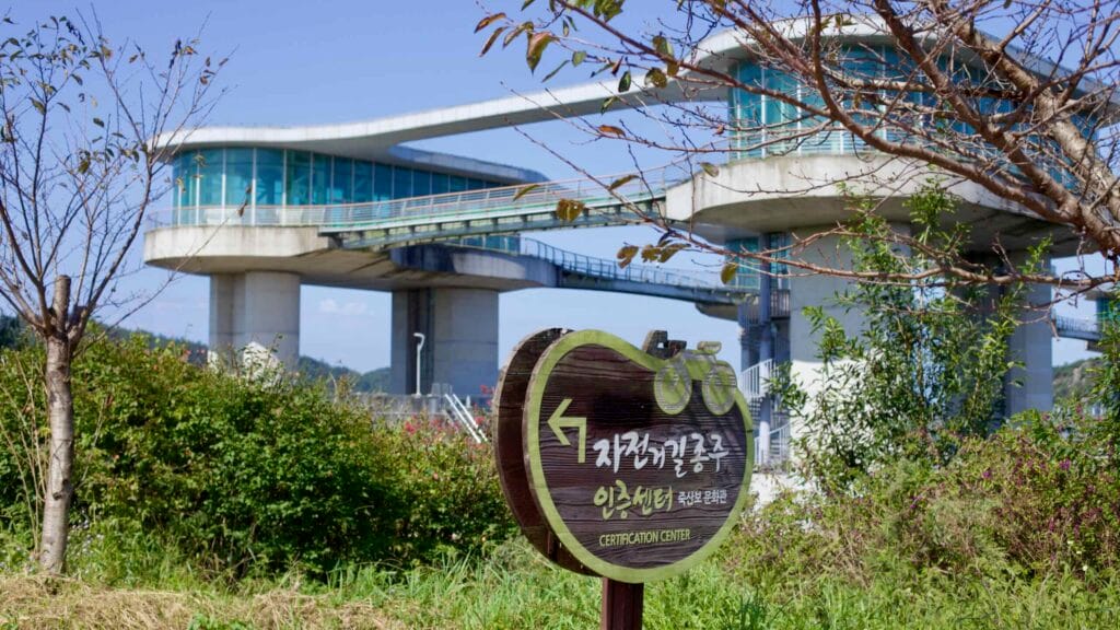 Wooden sign directs cyclists to Juksanbo Certification Center along the Bike Path.