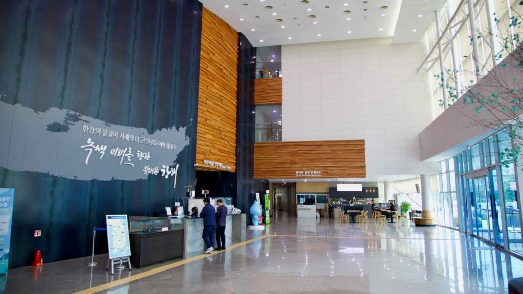 Gyeongin Ara Waterway Integrated Center lobby with reception, high ceilings, and a cafe.