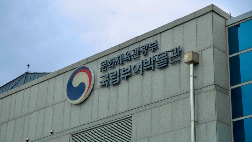 Angled view of the Buyeo National Museum's granite facade, featuring the government emblem and Korean name.