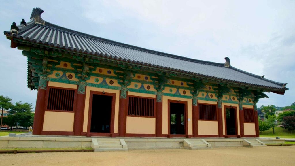 A restored lecture hall with vibrant dancheong detailing stands on the Jeongnimsa Temple Site.