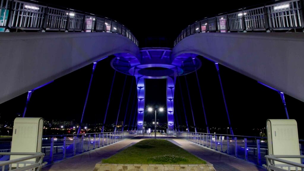 A nighttime view from beneath the central observatory of Geumgang Pedestrian Bridge.