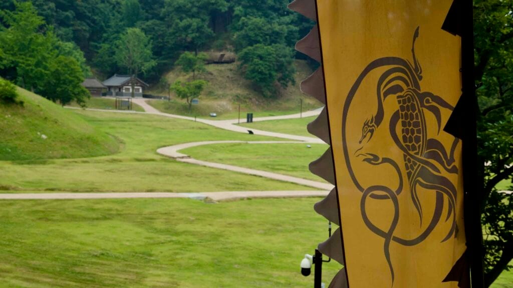 Dragon banner flutters over Gong Mountain Fortress, with paths leading to a traditional gate.