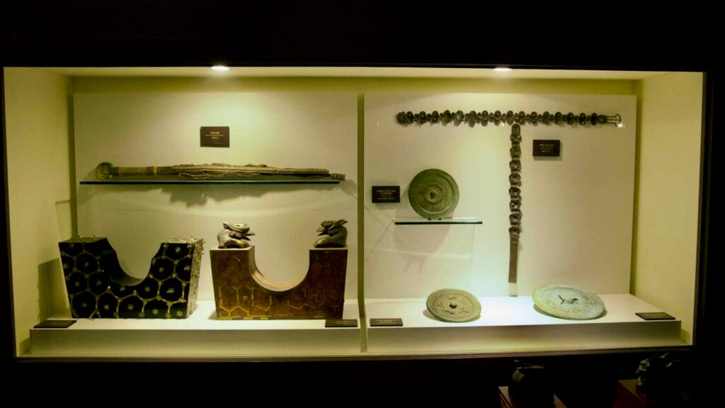 Baekje artifacts from the Tomb of King Muryeong, including swords and ceremonial items, displayed in a museum.