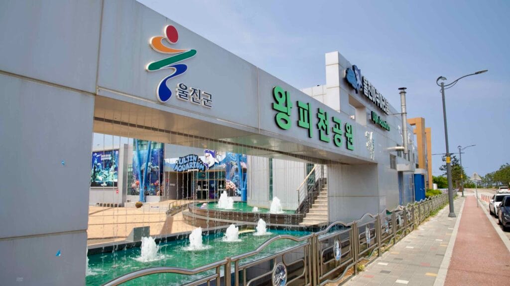 The front entrance to Wangpi Nature Park features a cascading water display and signage for the Uljin Aquarium, a major family attraction along the East Sea coast.