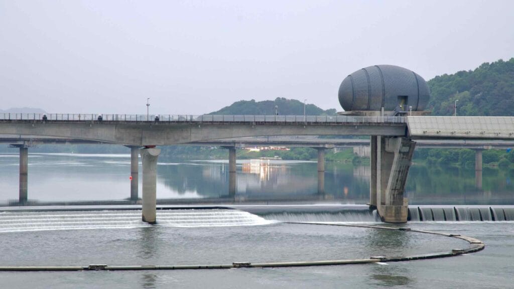 The westernmost control tower of Ipo Weir stands over calm waters, where stepped spillways and mirrored reflections mark the South Han River’s tranquil flow.