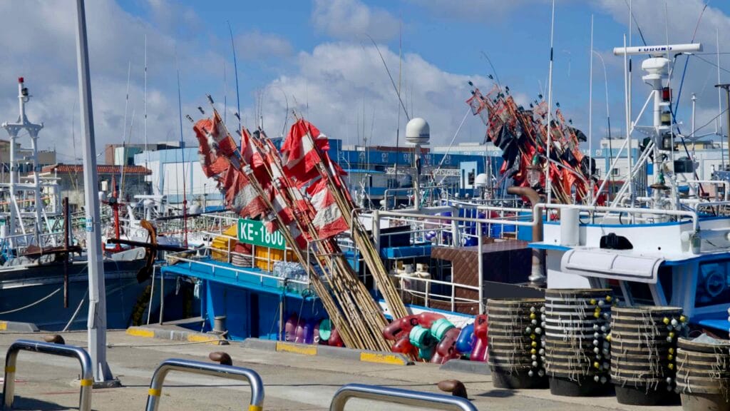 Signal flags and fishing gear crowd trawlers at Hanlim Port.