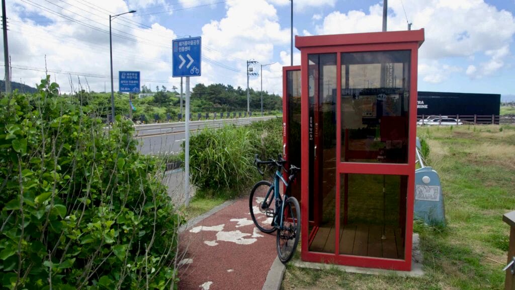 Red certification shelter with bicycle at Haegeoreum Park.