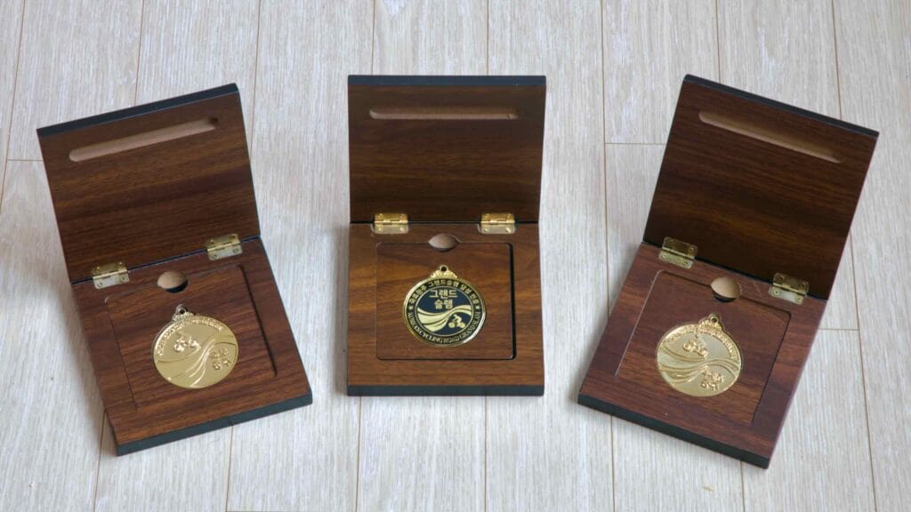 Medals awarded for Cross-Country (left), Grand Slam (center), and 4 Rivers (right) cycling challenges.