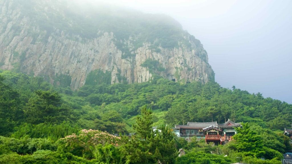 Bomunsa Temple sits at the foot of Sanbang Mountain’s sheer volcanic cliffs on Jeju’s south coast.