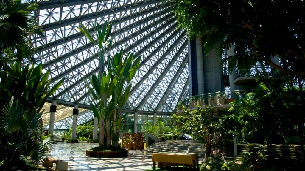 Yeomiji’s grand atrium features tropical plants, stepped seating, and event tables.