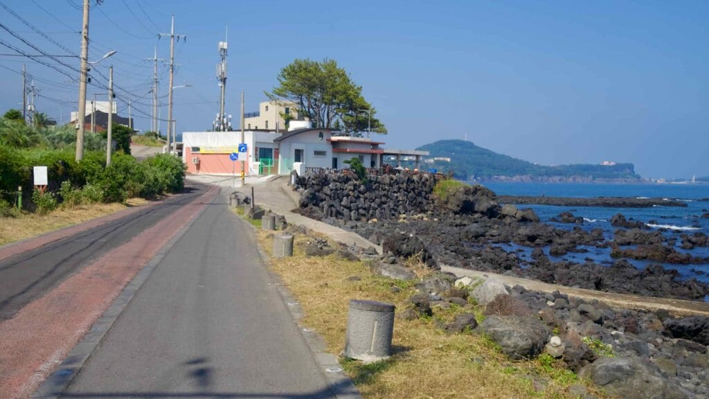 A quiet road runs beside the volcanic coast in Beophwan village.