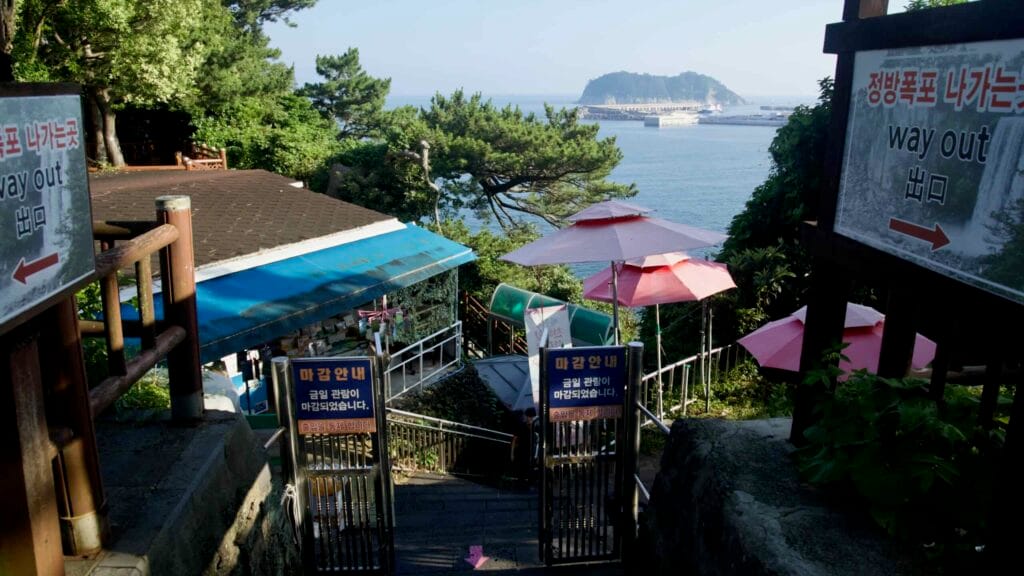 Munseom Island rises beyond Seogwipo Harbor’s long breakwaters and piers.