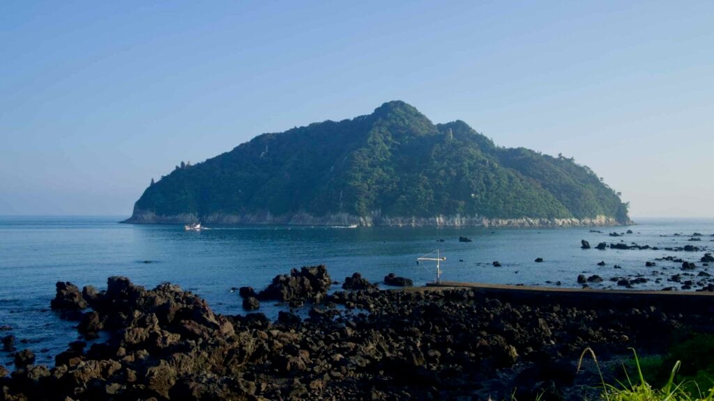 Basalt rocks frame a wide view toward Seopseom Island.