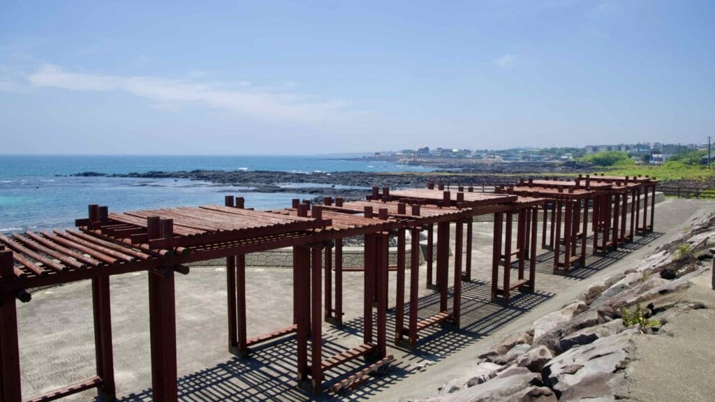 Wooden pergolas overlook the lava shore and tide pools on Jeju’s eastern coast.
