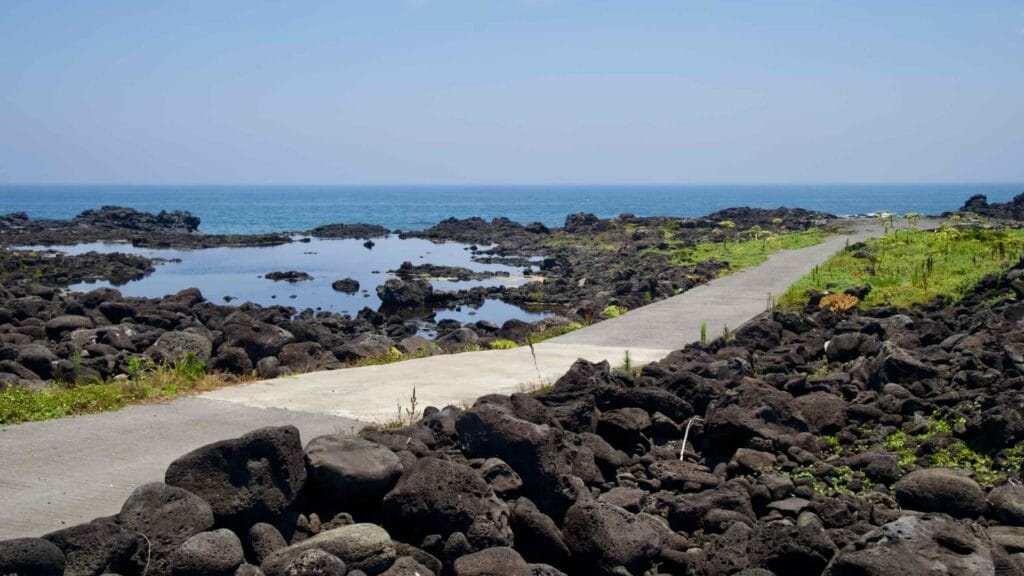 Paths cross black lava to calm tidal pools on the Onpyeong shore.