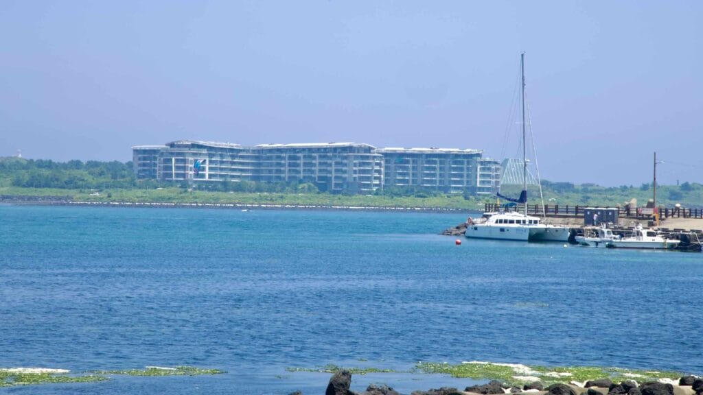 Boats at Sinyang Port sit opposite the Phoenix resort and glass pyramid on Seopjikoji.