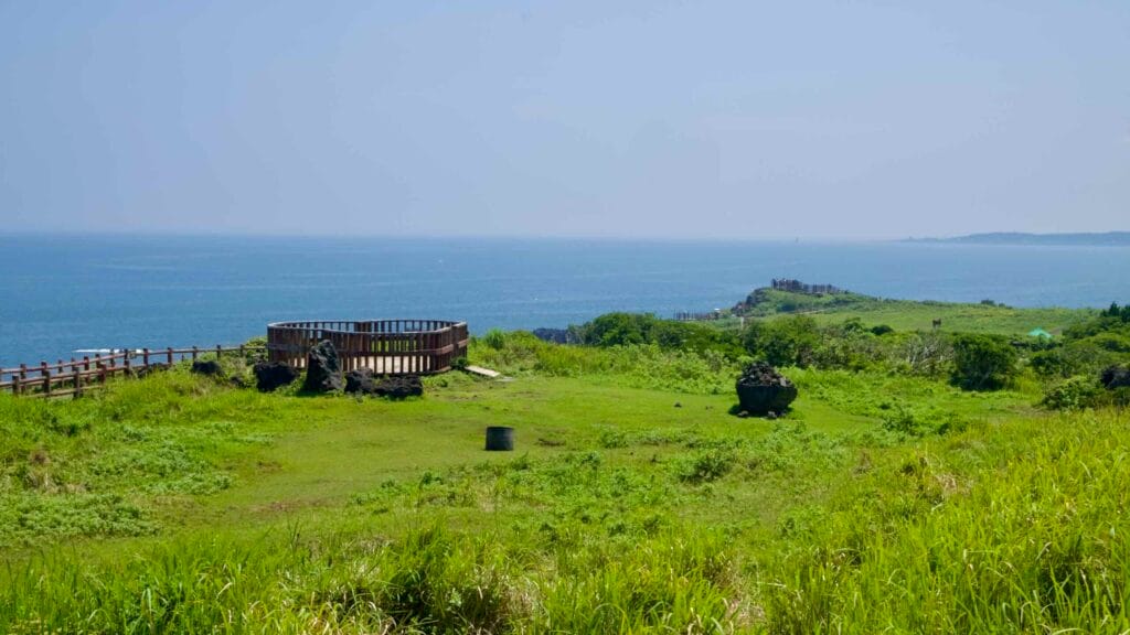 A clifftop deck overlooks Seopjikoji’s volcanic shoreline and the blue East Sea.