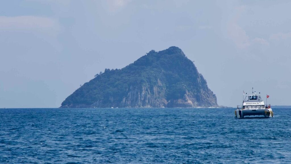 A tour catamaran approaches Seopseom Island off Seogwipo.