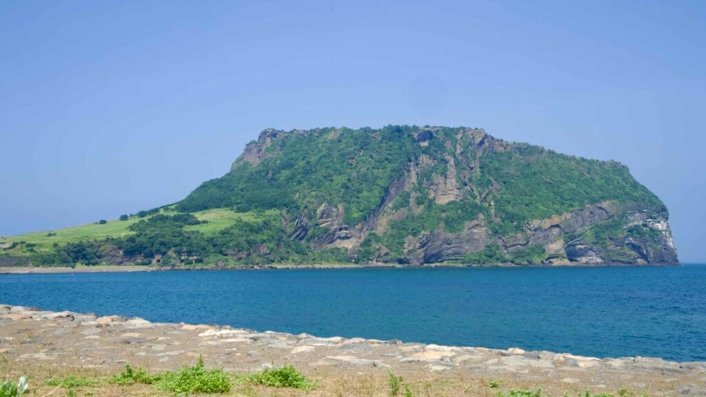 Seongsan Ilchulbong fills the frame across the bay, its grassy slopes and dark tuff.