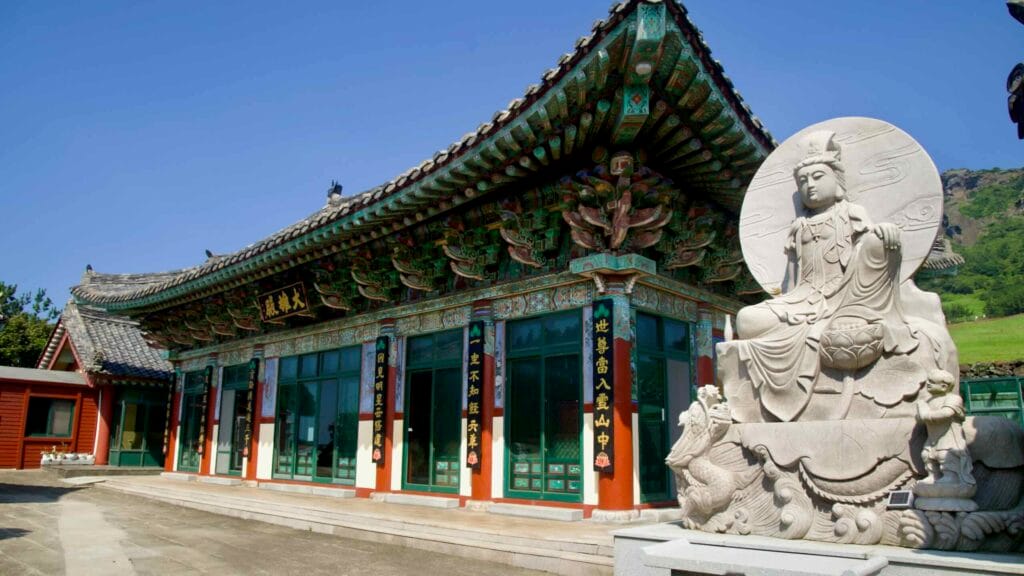 A white bodhisattva statue sits beside Dongamsa Temple’s main hall.