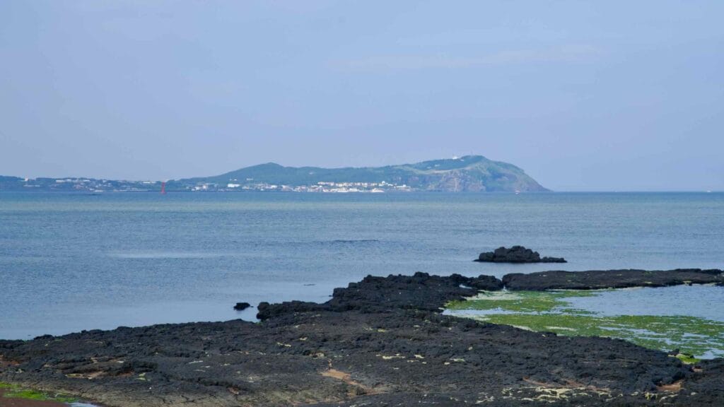 Basalt flats lead toward Udo Island from the peaceful shore at Songnan Port.
