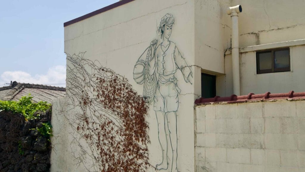 A wire-art haenyeo diver decorates a wall in Gimnyeong’s Metal Craft Mural Village.